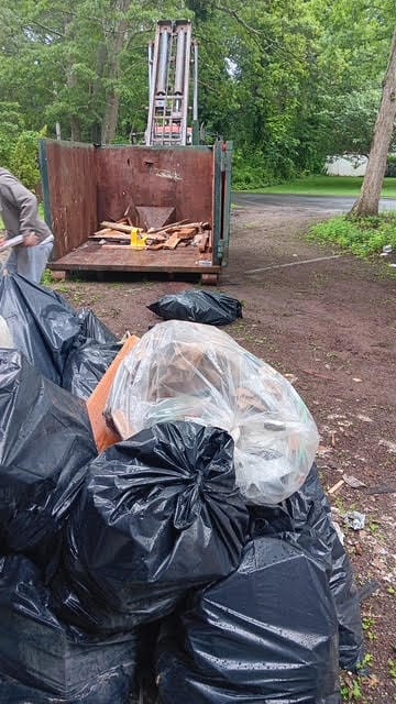 Cigna crew loading junk and debris into dumpster